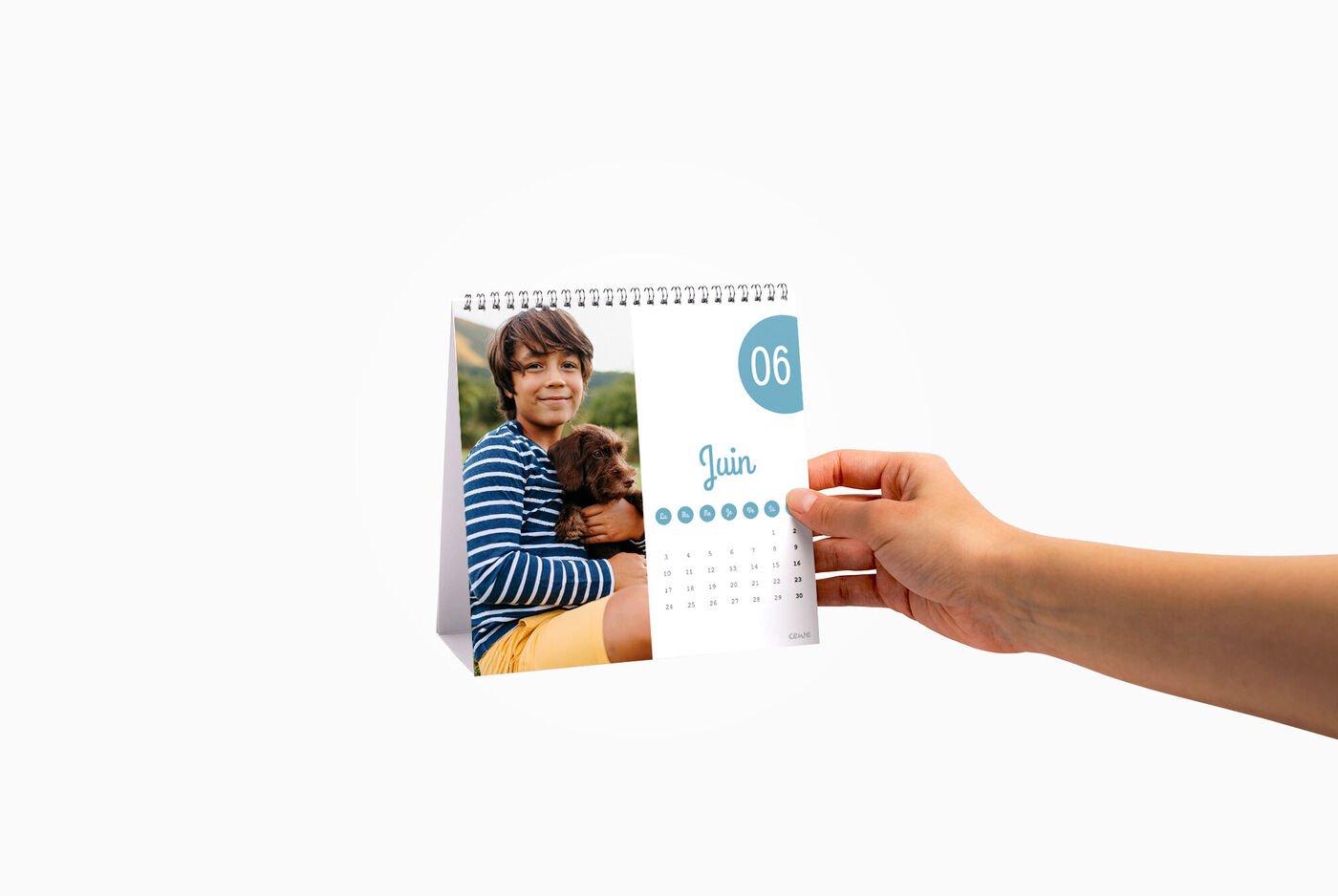 Main tenant un calendrier affichant un texte pour le mois de juin, avec une image en haut
