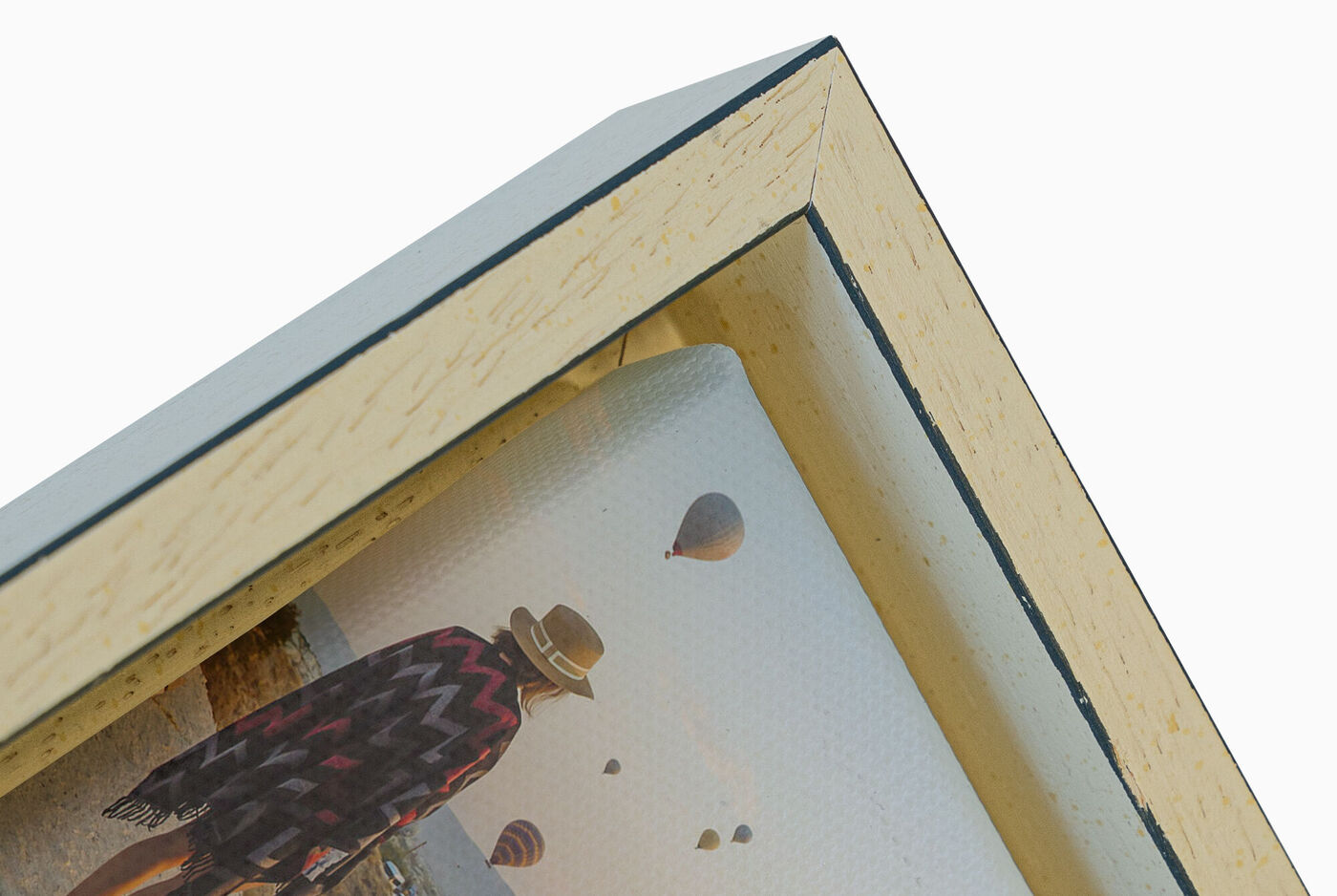 Vue détaillée d'un cadre photo avec une personne porteuse d'un chapeau et des ballons en arrière-plan.