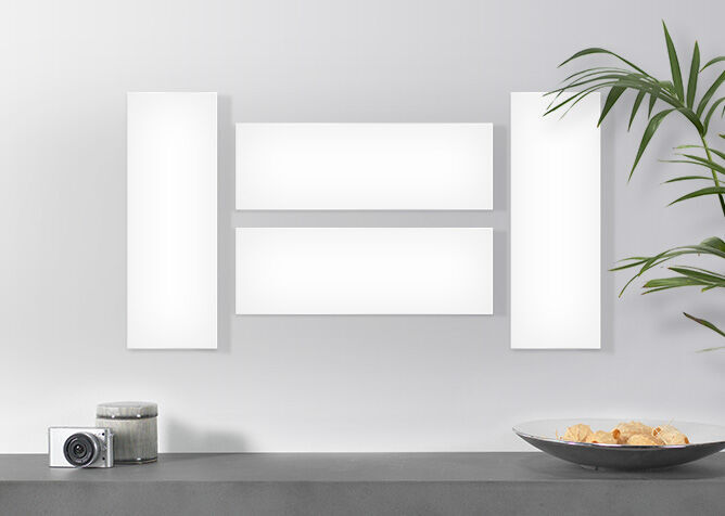 Des images murales de différentes tailles, avec un vase de plantes et un appareil photo à côté