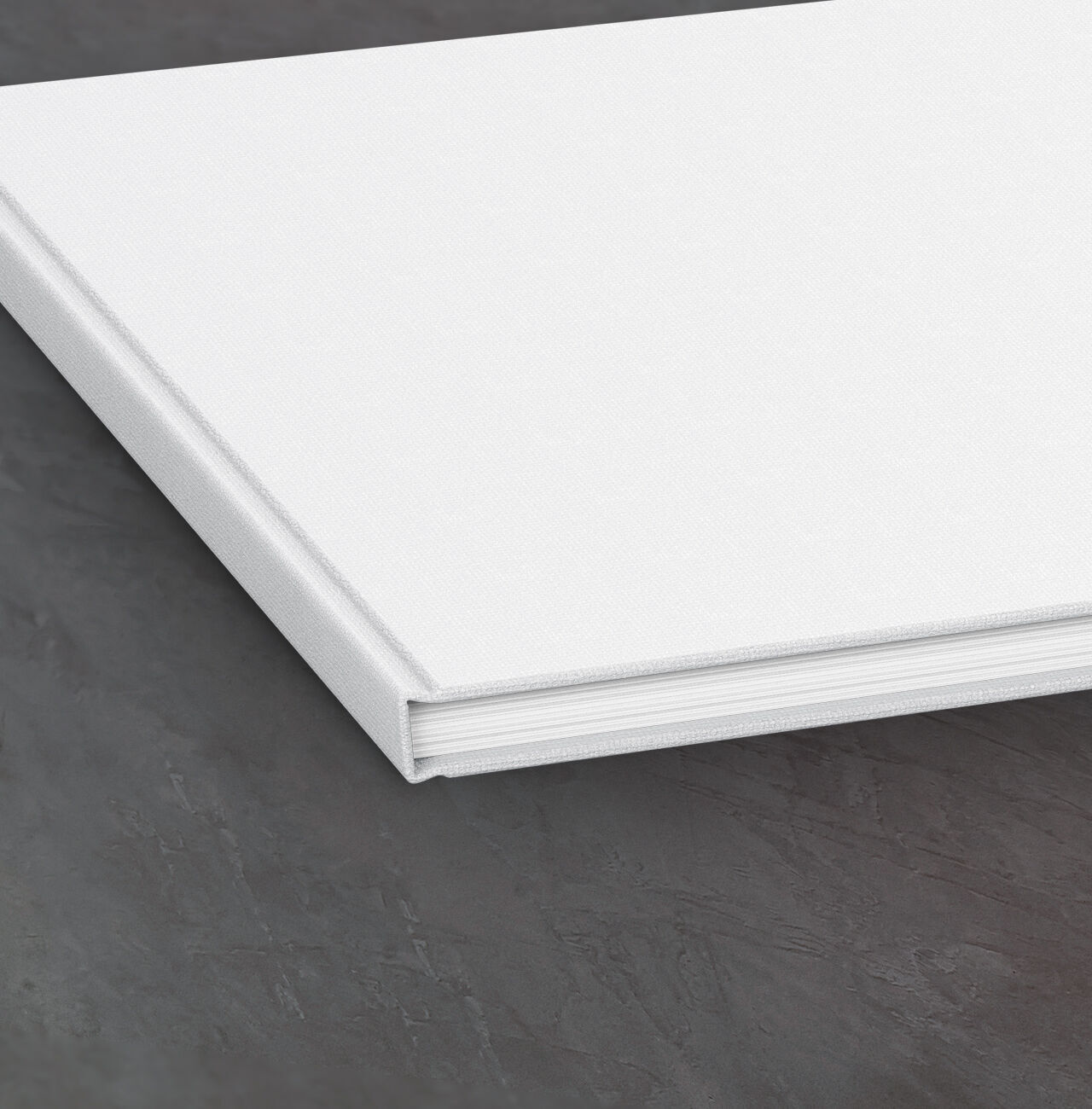 Un CEWE FOTOBUCH fermé sur une table sombre.