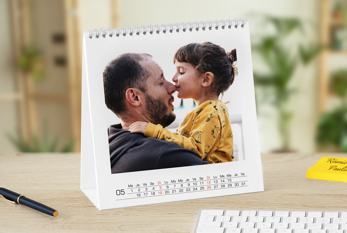 Un calendrier de table montre une photo tendre d'un enfant dans les bras d'un adulte.