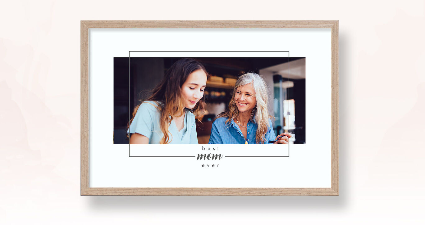 Deux femmes heureuses regardent une photo ensemble, dans un cadre.