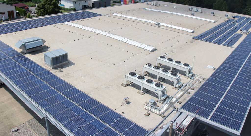 Toit avec panneaux solaires et climatiseurs au premier plan