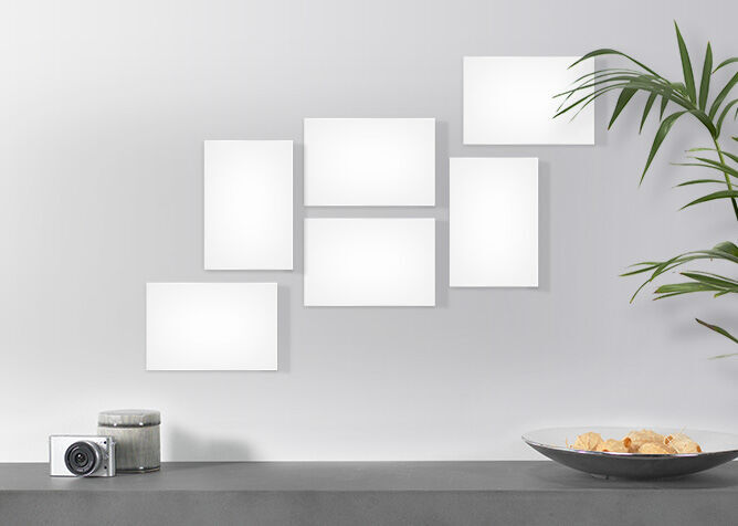 Cadres blancs accrochés au mur, avec un bol de snacks et un appareil photo en dessous