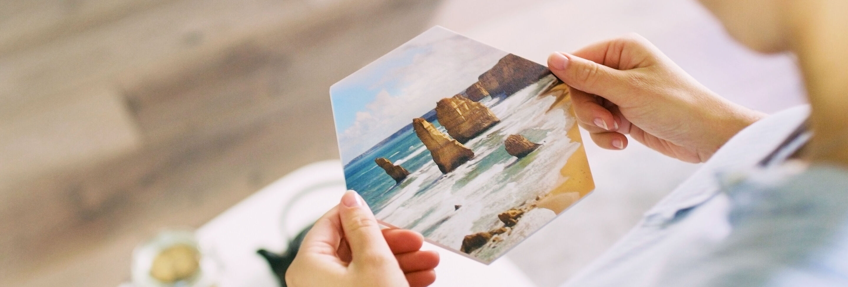 Une personne tient une image avec des motifs de plage et de rochers