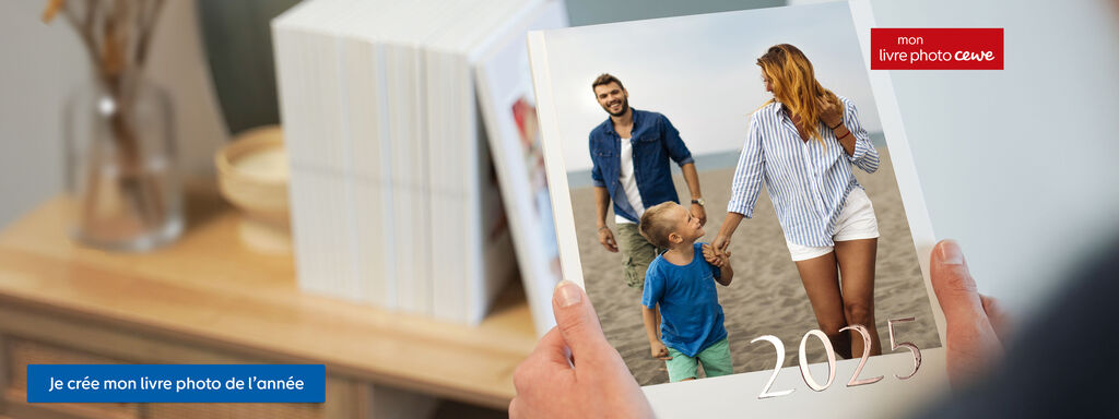 Un couple avec un enfant tient un album photo à la plage. Ils profitent du moment ensemble et semblent heureux.