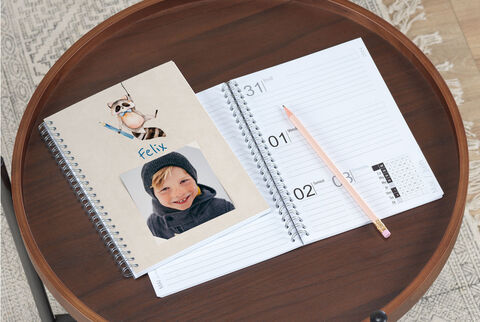 Un carnet personnel et un calendrier sur une table, décorés avec un crayon de couleur.