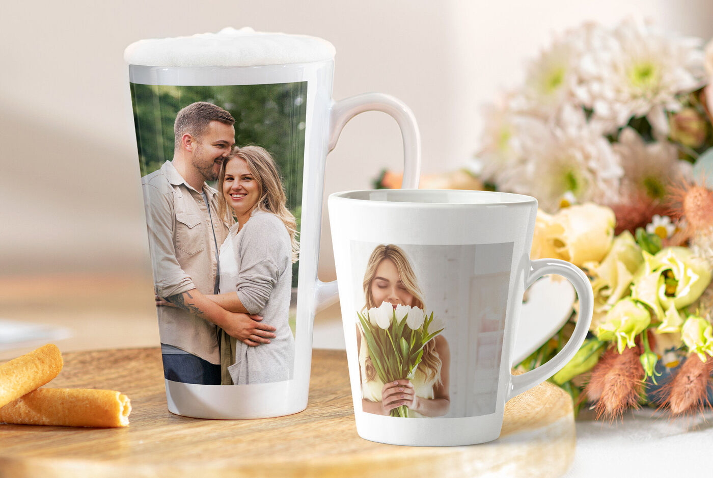 Deux tasses personnalisées devant un bouquet de fleurs