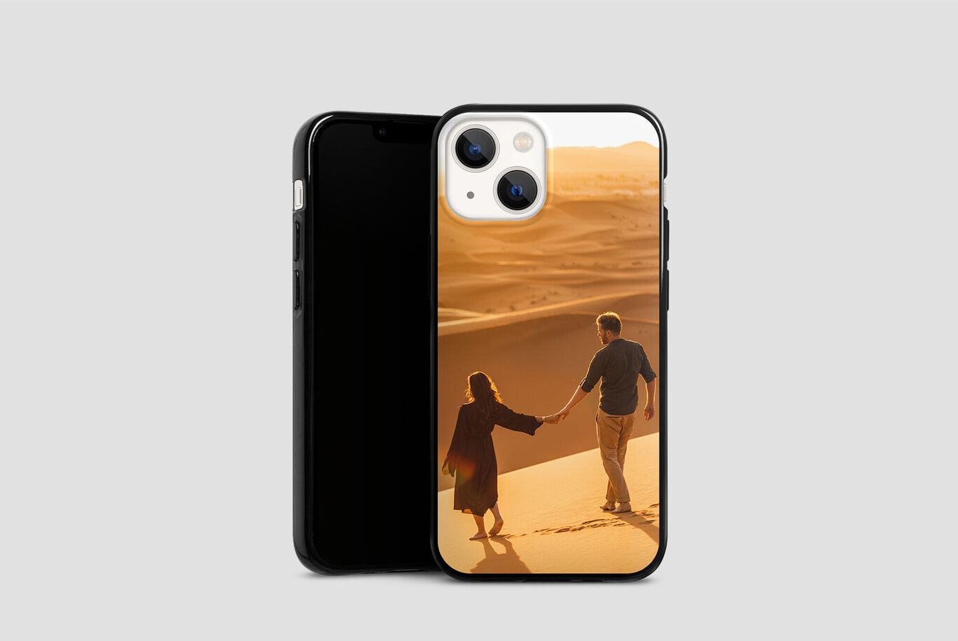 Un couple se tient par la main et traverse un paysage désertique au coucher du soleil