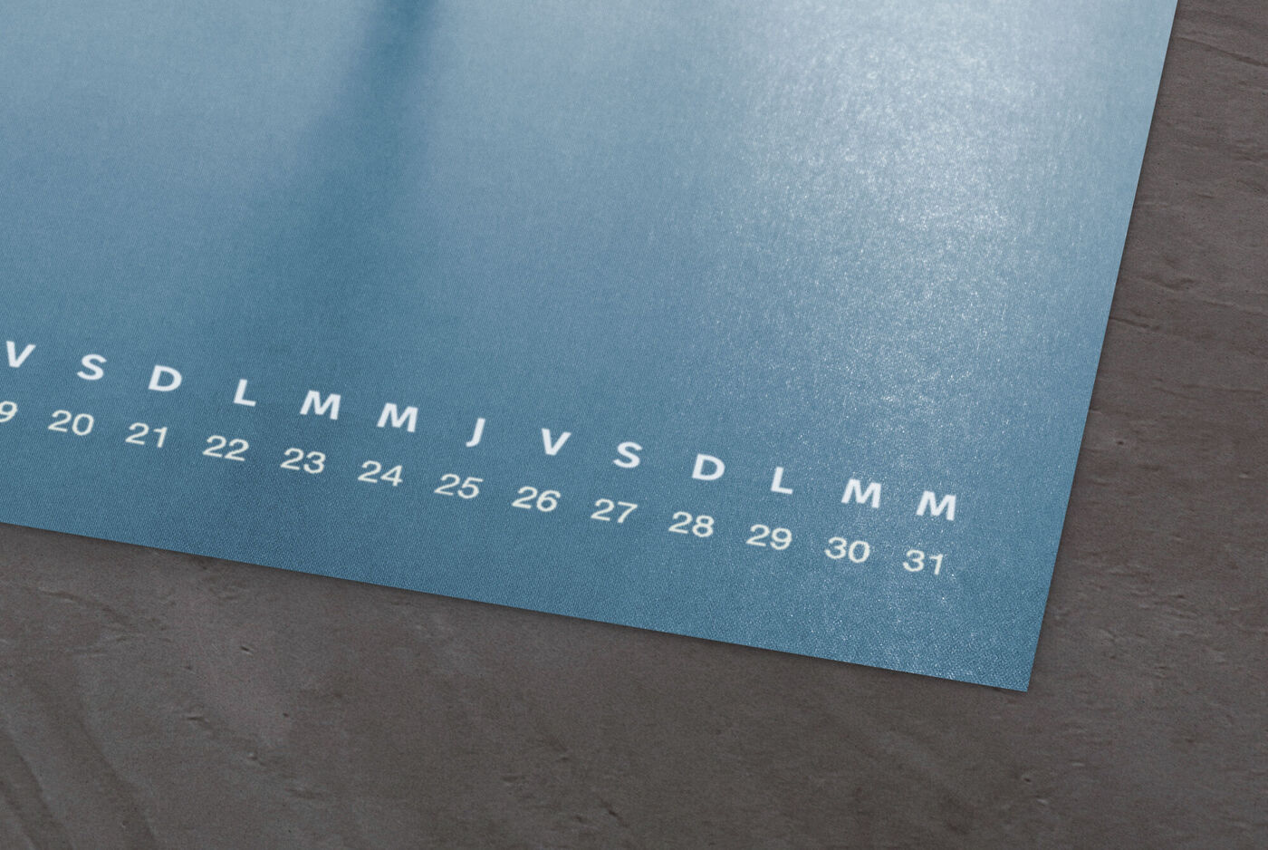 Calendrier mensuel sur une table avec surface bleue.
