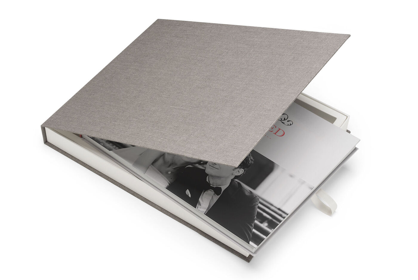 Un CEWE PHOTOBOOK ouvert avec une couverture rigide grise élégante et une photo romantique en noir et blanc à l'intérieur