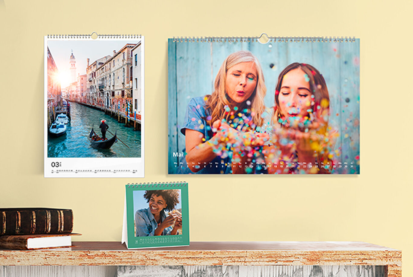 Deux calendriers muraux et un calendrier de table avec photos sur un mur.