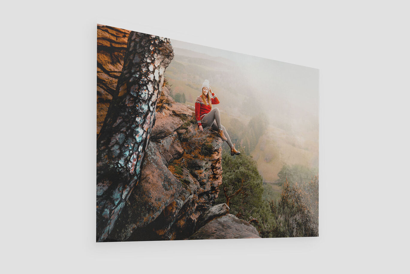 Une femme assise sur une pierre dans la nature, profitant de la vue.