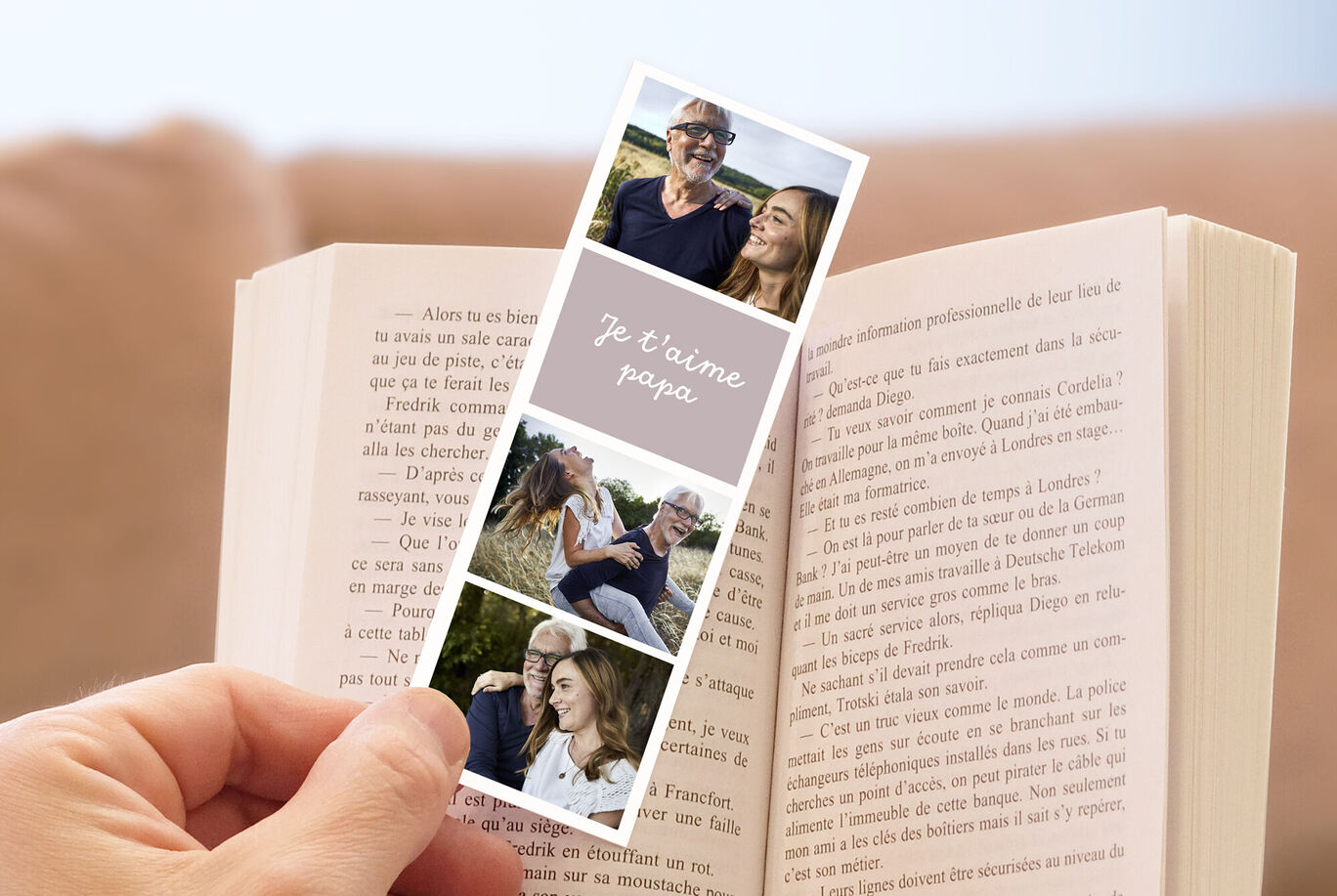 Une personne tenant une bande photo de famille et un livre.