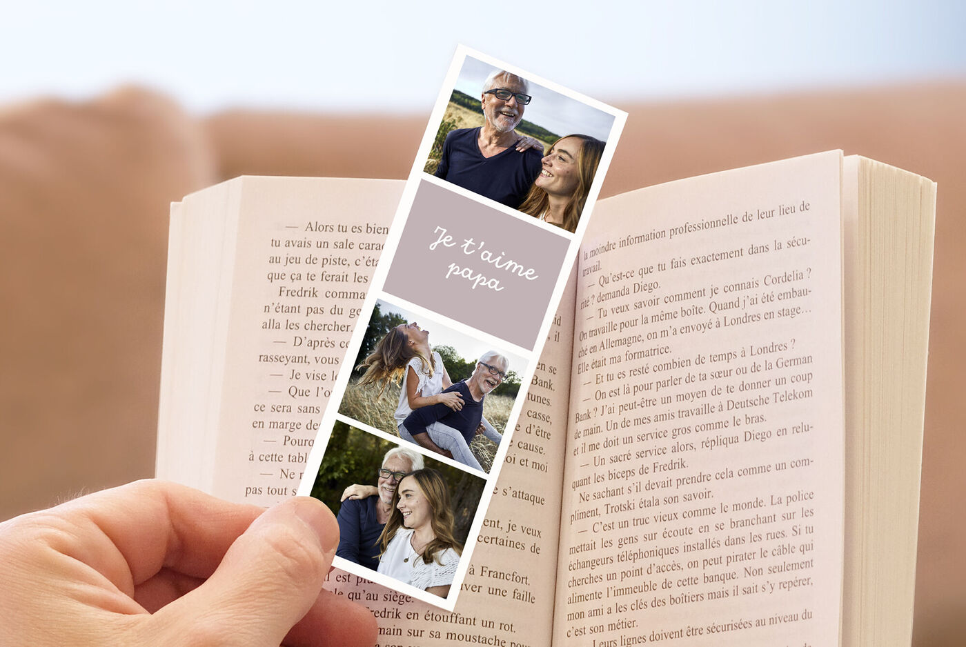 Une personne tenant une bande photo de famille et un livre.