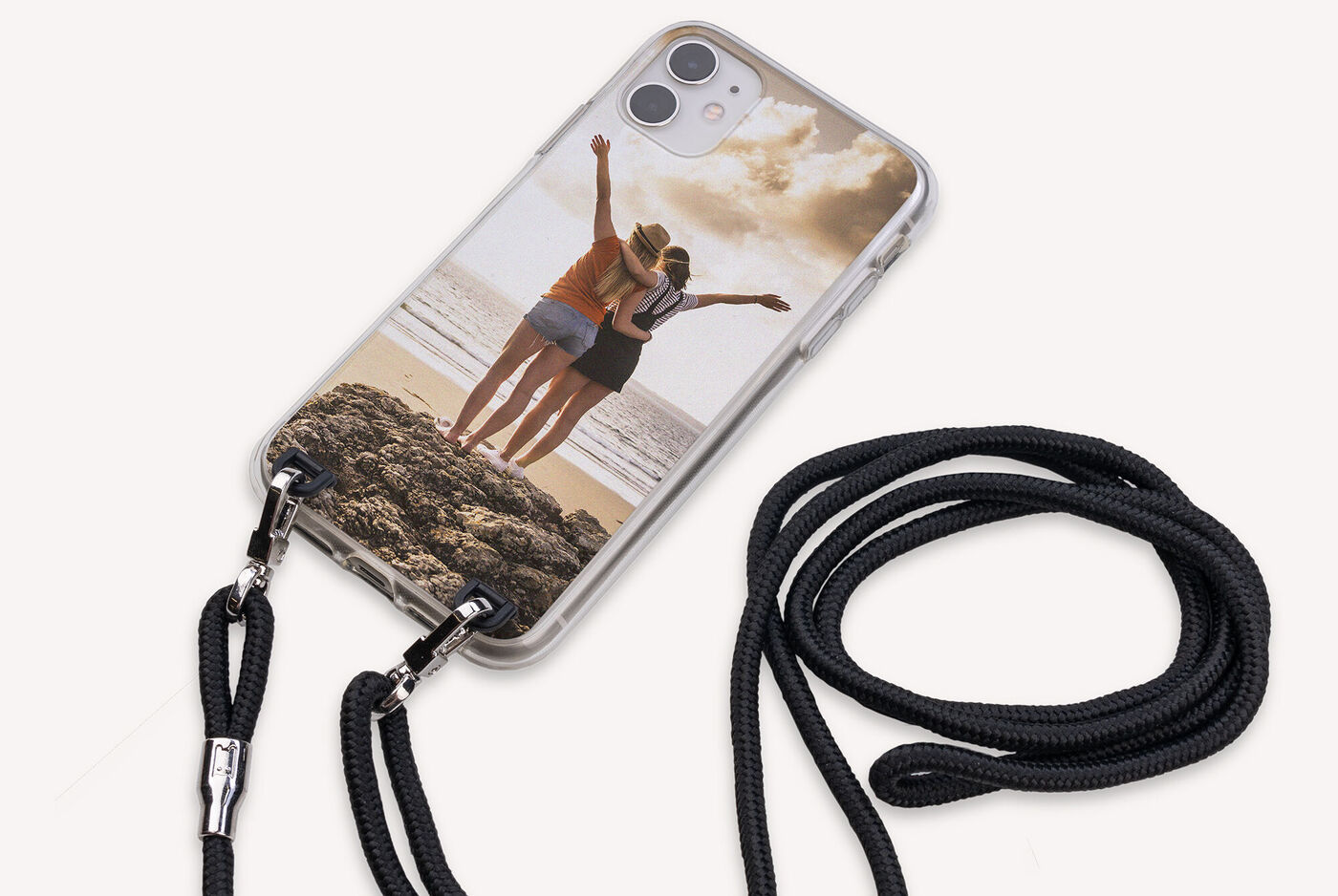 Deux personnes profitent d'une journée à la plage avec un smartphone dans une coque personnalisée.