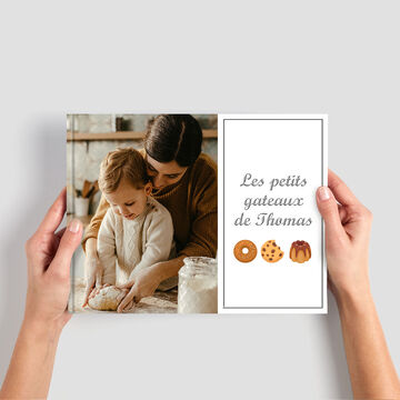 Deux mains tenant un livre de recettes pour petits gâteaux