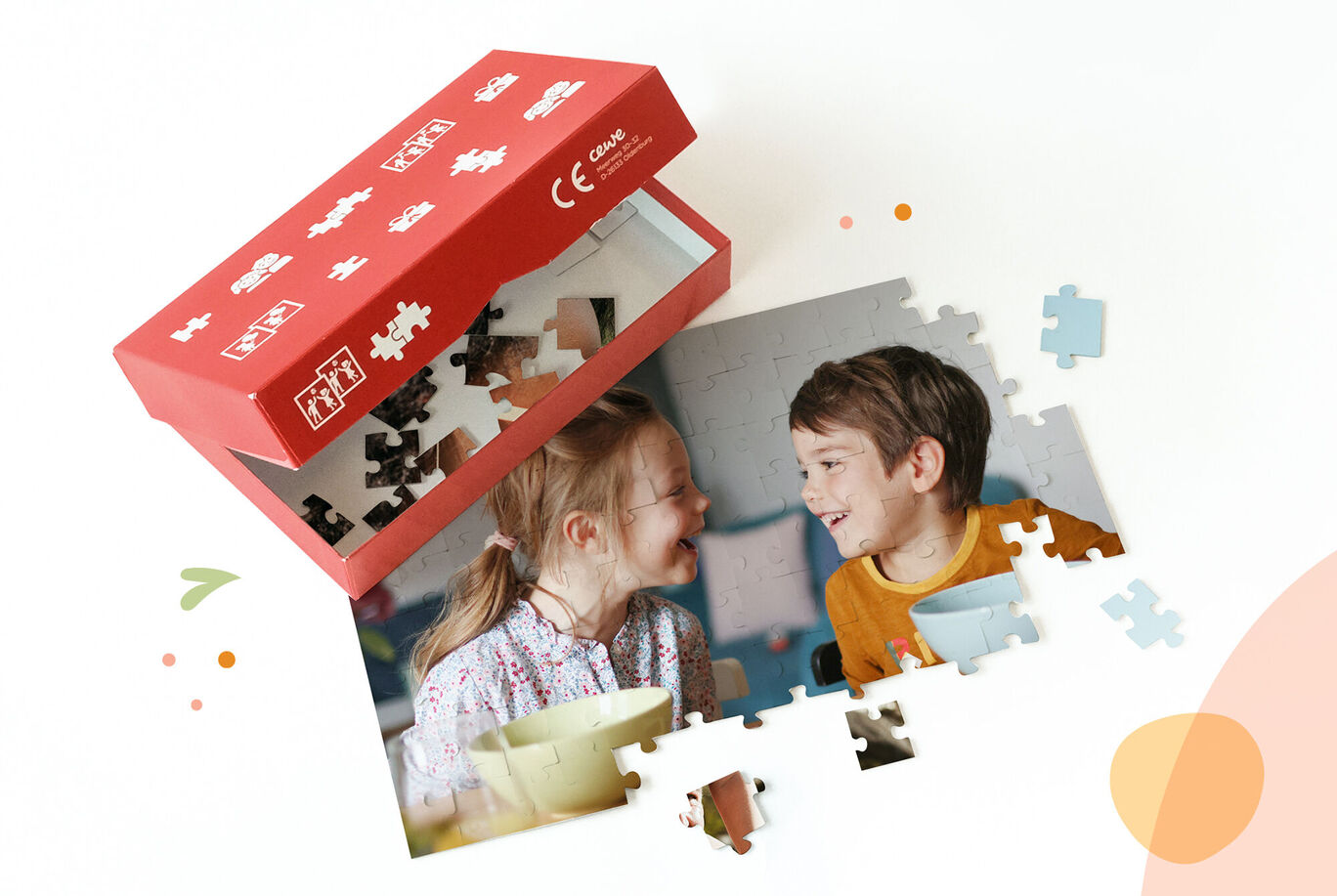Une boîte ouverte avec des pièces de puzzle et deux photos d'enfants en train de jouer.