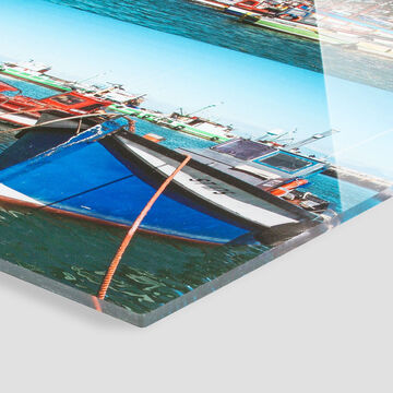 Un bateau coloré tangue doucement sur l'eau dans un port avec d'autres bateaux en arrière-plan