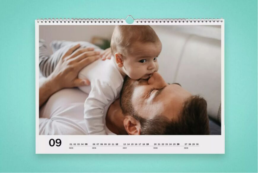Un père embrasse son bébé sur une page de calendrier.