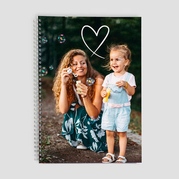 Une mère fait des bulles de savon avec son petit enfant à l'extérieur