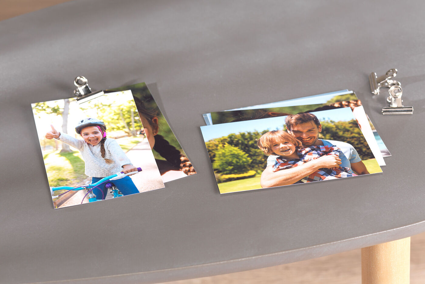 Des photos colorées présentées sur une table, avec un enfant sur un vélo et un adulte tenant un enfant.