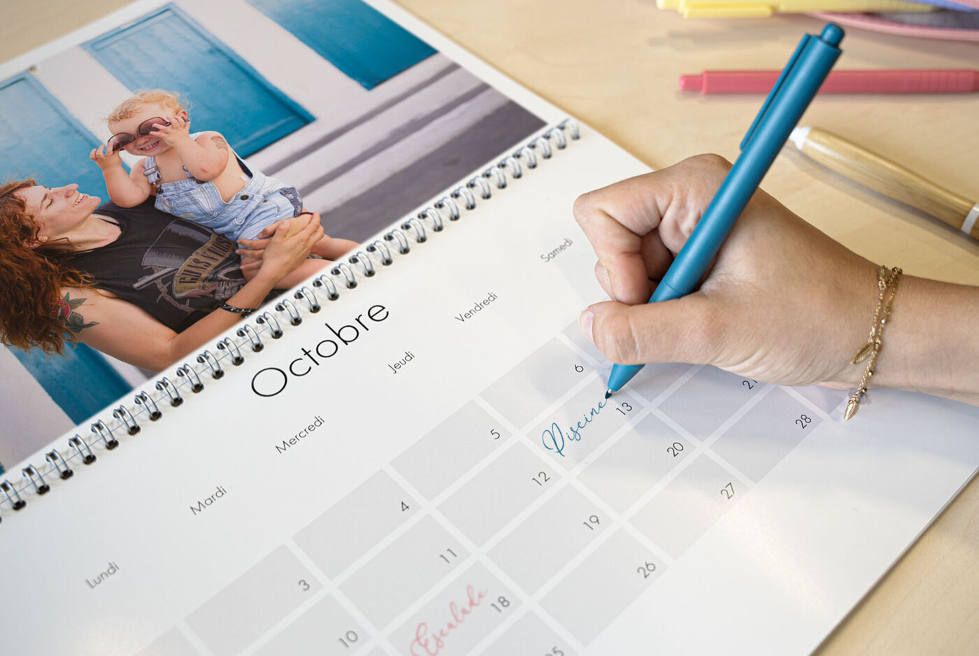 Main écrivant sur un calendrier photo double page