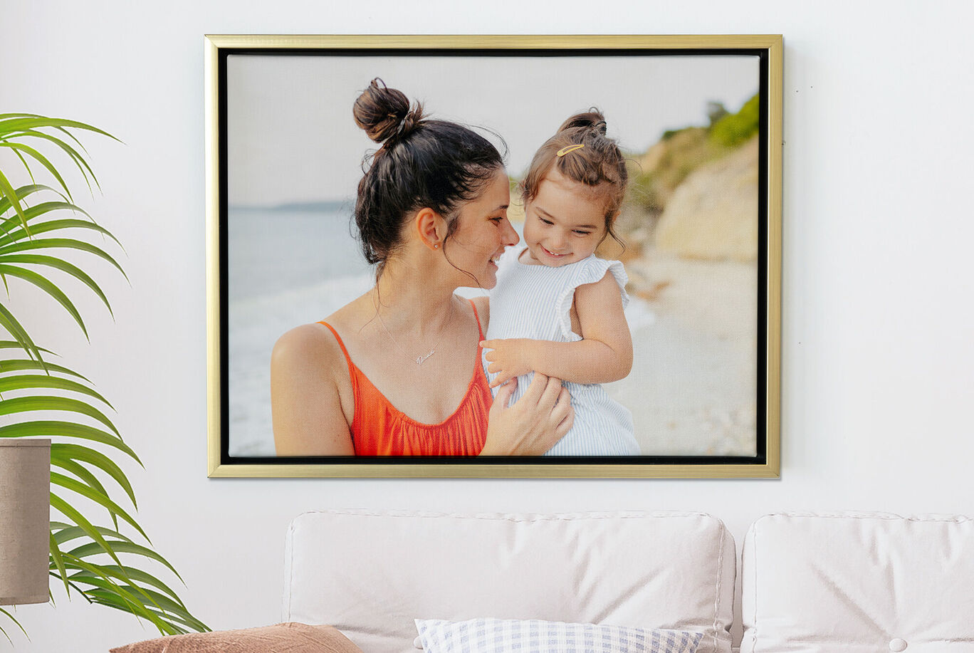 Une mère tient son enfant sur la plage. Ils profitent tous deux de la journée au bord de la mer.