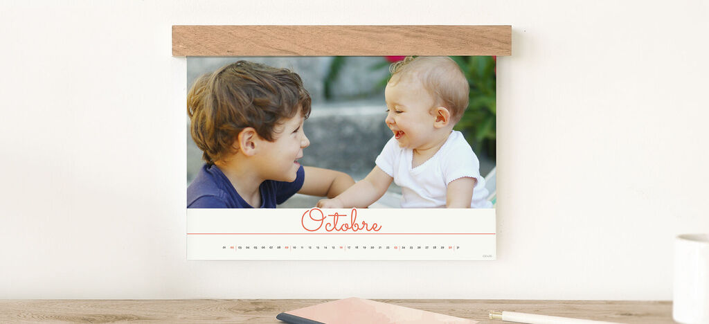 Un calendrier photogénique montre le mois d'octobre. Deux enfants jouent ensemble.