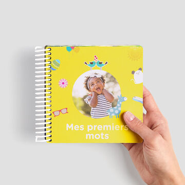 Couverture de livre colorée et spiralée avec un jouet et des illustrations joyeuses, représentant un livre pour enfants.