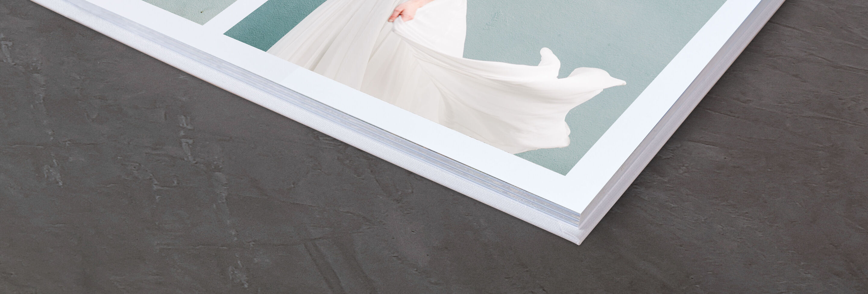 Gros plan d'un album photo CEWE ouvert avec une mise en page élégante et des pages brillantes.