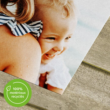 Deux personnes souriantes posent avec un cadre photo, mettant en avant un matériau écologique.