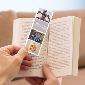 Un marque-page soigneusement conçu avec des photos de vacances, tenu dans un livre ouvert.