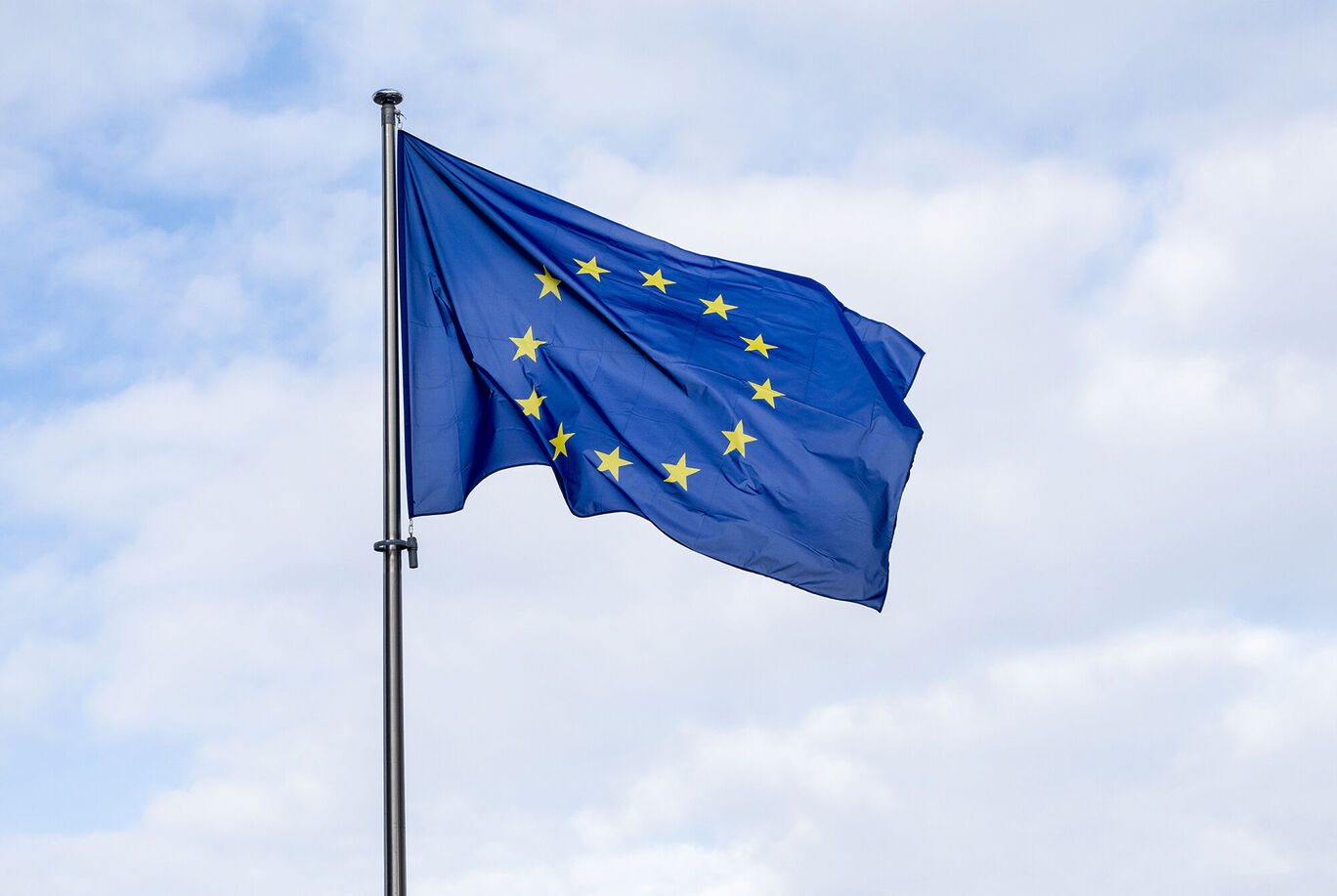 Drapeau de l'Union Européenne avec arrière-plan bleu et étoiles jaunes flottant au vent