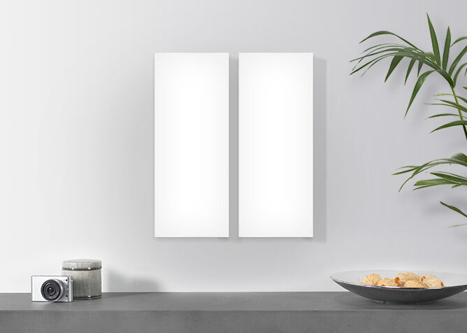 Deux cadres blancs vides au mur, plantes et assiettes décoratives en arrière-plan