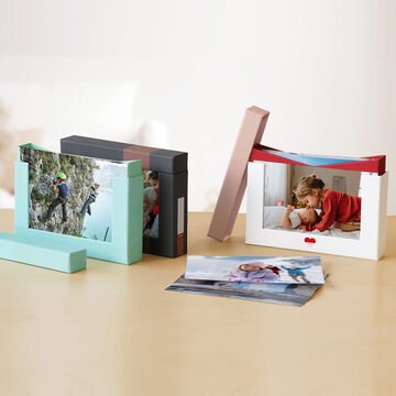 Deux albums CEWE créatifs et des photos sur une table