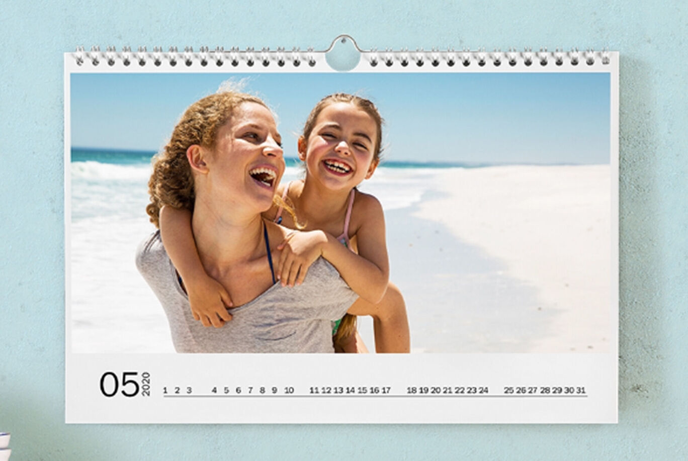 Une personne joyeuse porte un enfant sur ses épaules à la plage, profitant d'un moment ensemble.