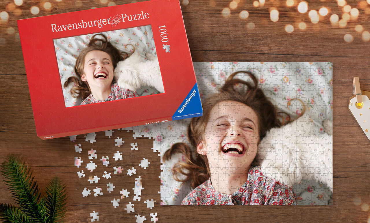 Un puzzle Ravensburger presque terminé sur une table, avec une boîte de puzzle à côté. La palette de couleurs est chaude et accueillante, entourée de décorations de Noël.