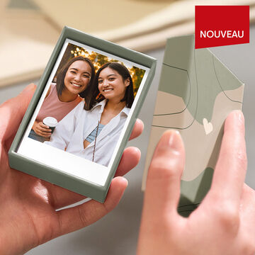 Deux personnes tiennent une photo de haute qualité semblable à un Polaroid.