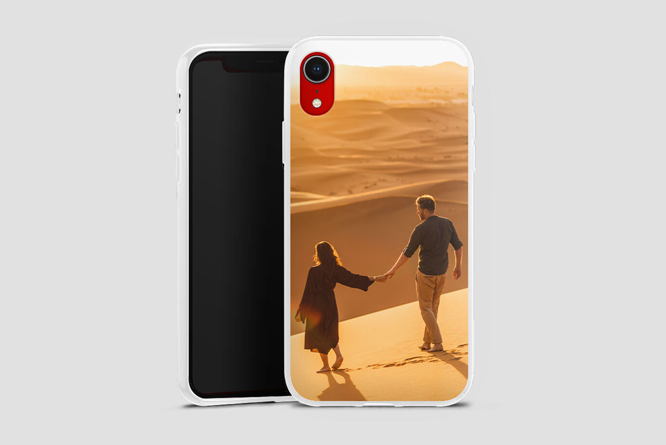 Un couple se tient par la main sur la plage, éclairé par la lumière du soleil