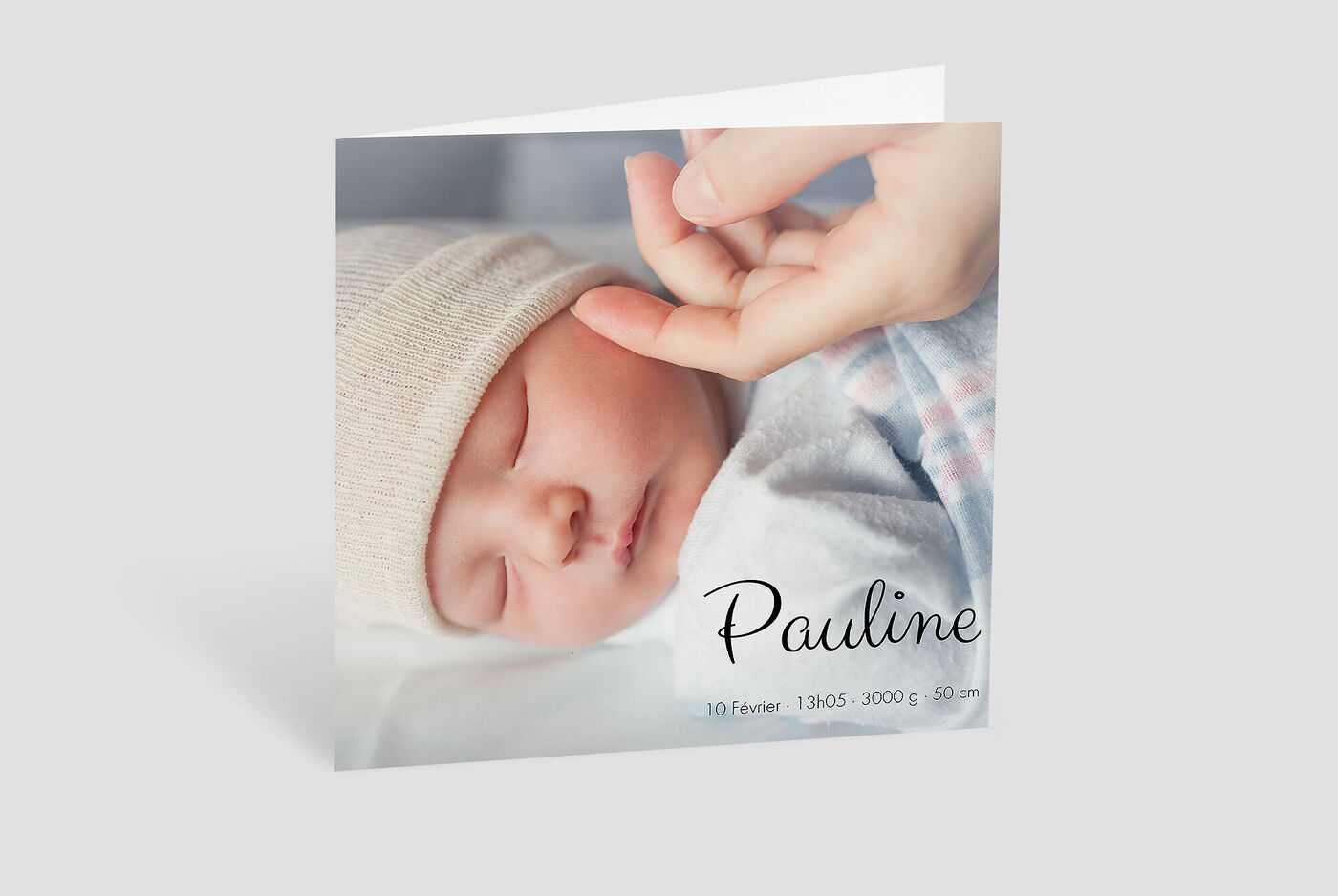 Une tendre photo d'un bébé tenu par une main, avec un design de carte de vœux personnalisé.