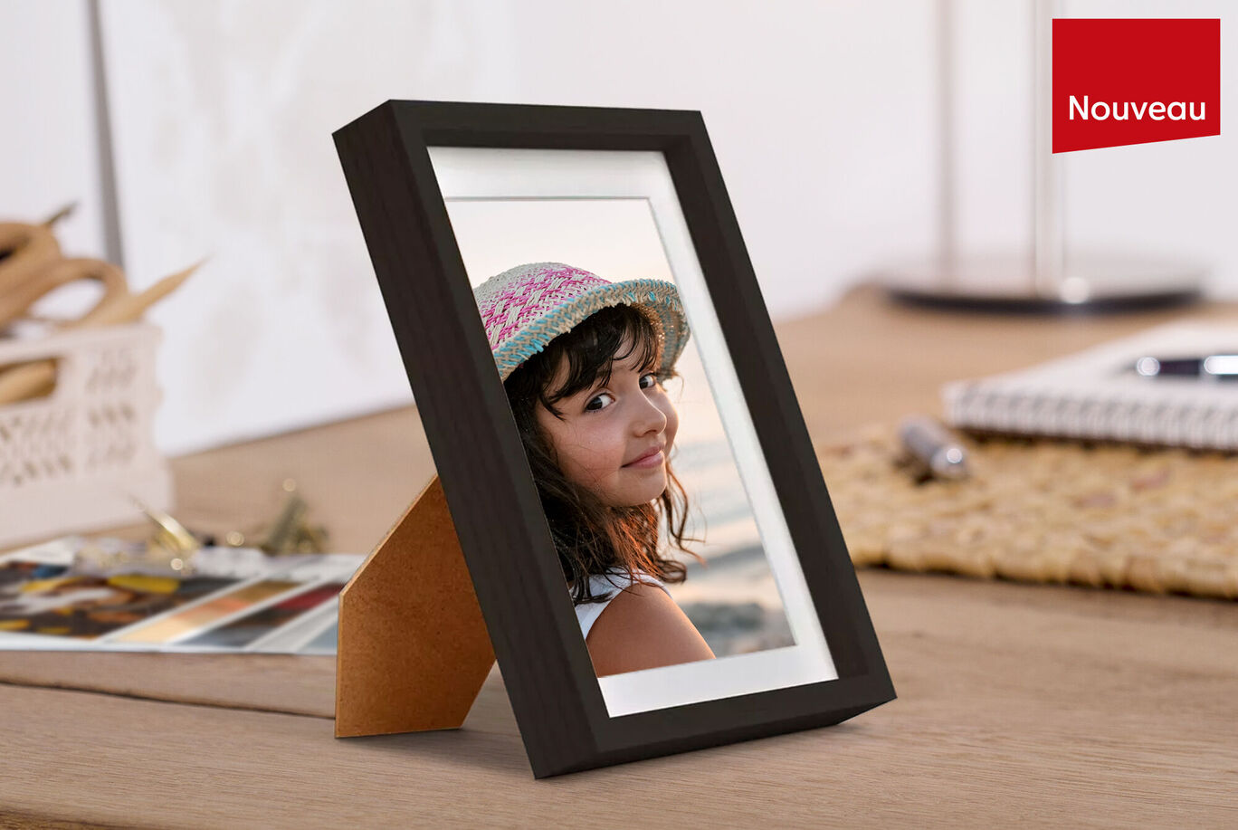 Une belle image dans un cadre élégant. La personne porte un chapeau de soleil et profite d'un beau moment. Des ustensiles créatifs sont visibles sur la table.