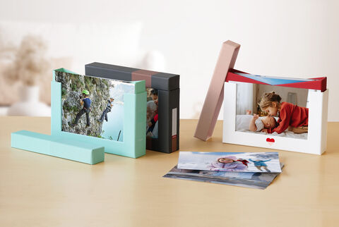 Trois boîtes-cadeaux photo différentes sur une table avec des photos au premier plan.