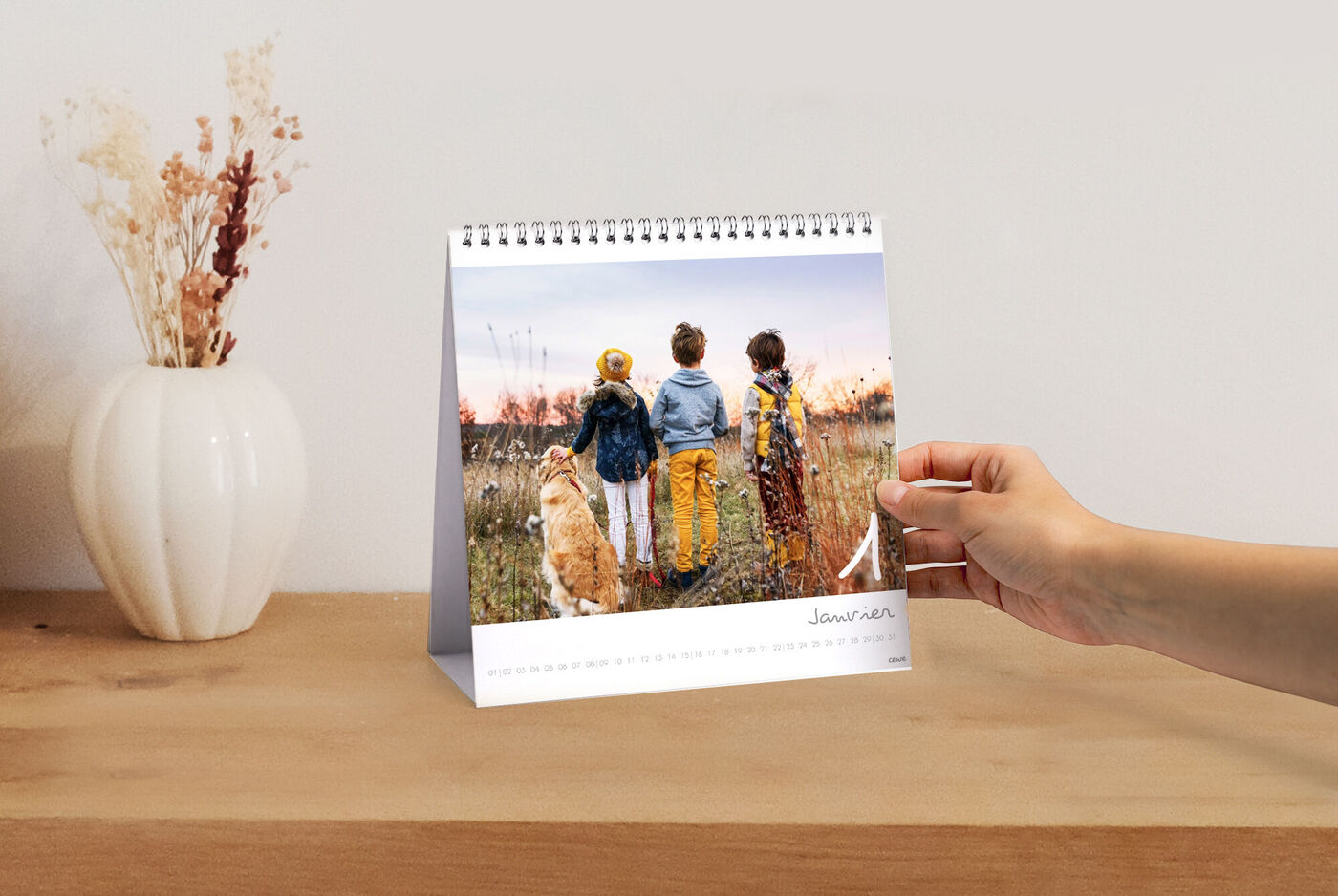 Trois enfants et un chien regardent un coucher de soleil devant un calendrier