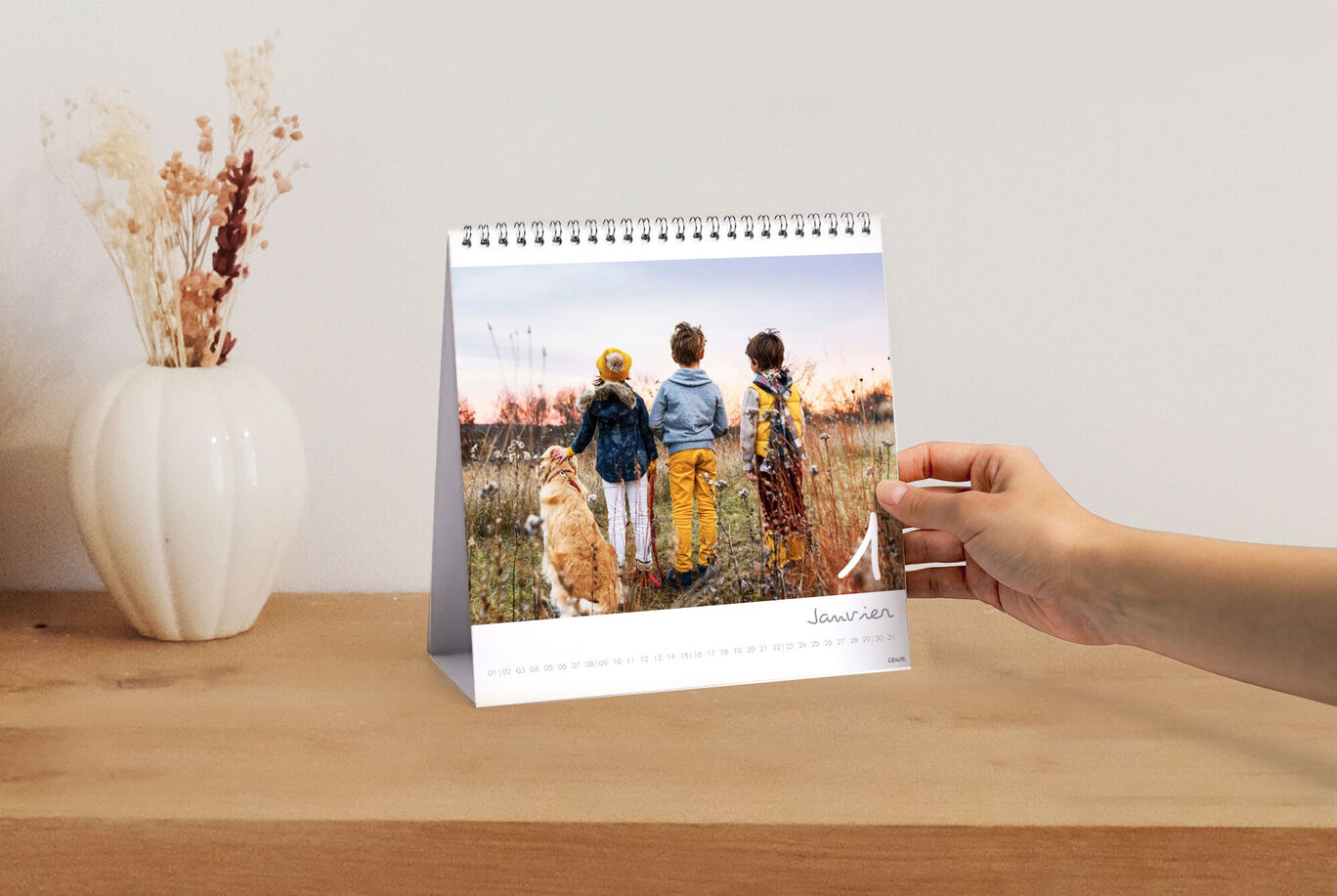 Trois enfants et un chien regardent un coucher de soleil devant un calendrier