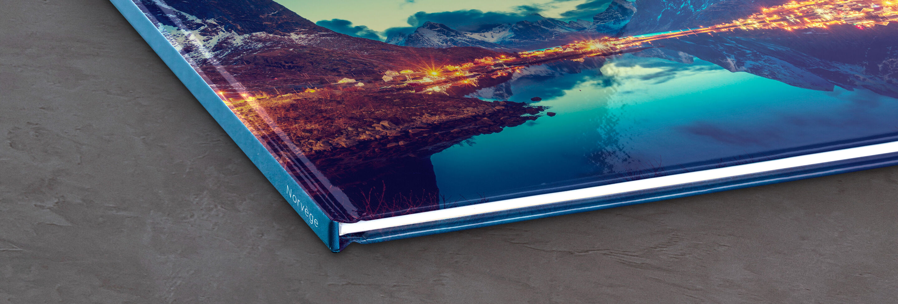 Gros plan d'un CEWE FOTOBUCH fermé avec une image spectaculaire sur la couverture.