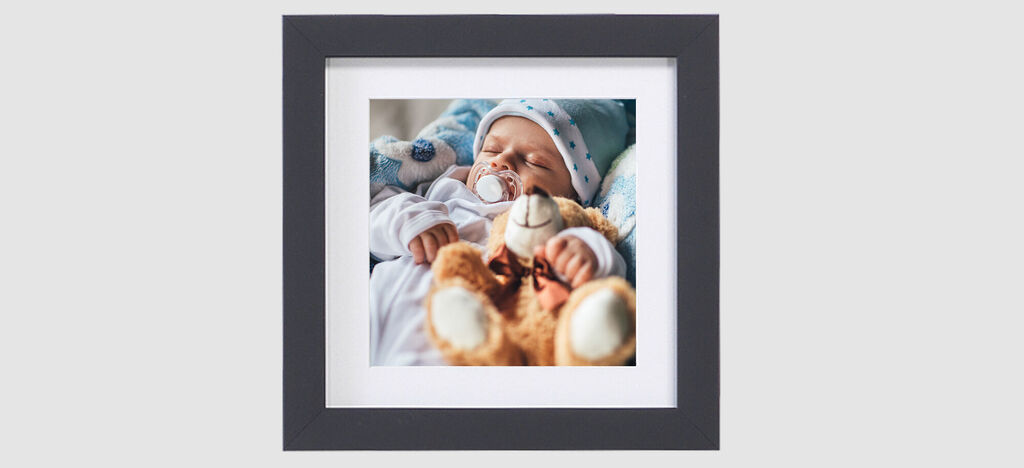 Un adorable bébé tient un teddy moelleux dans ses mains.