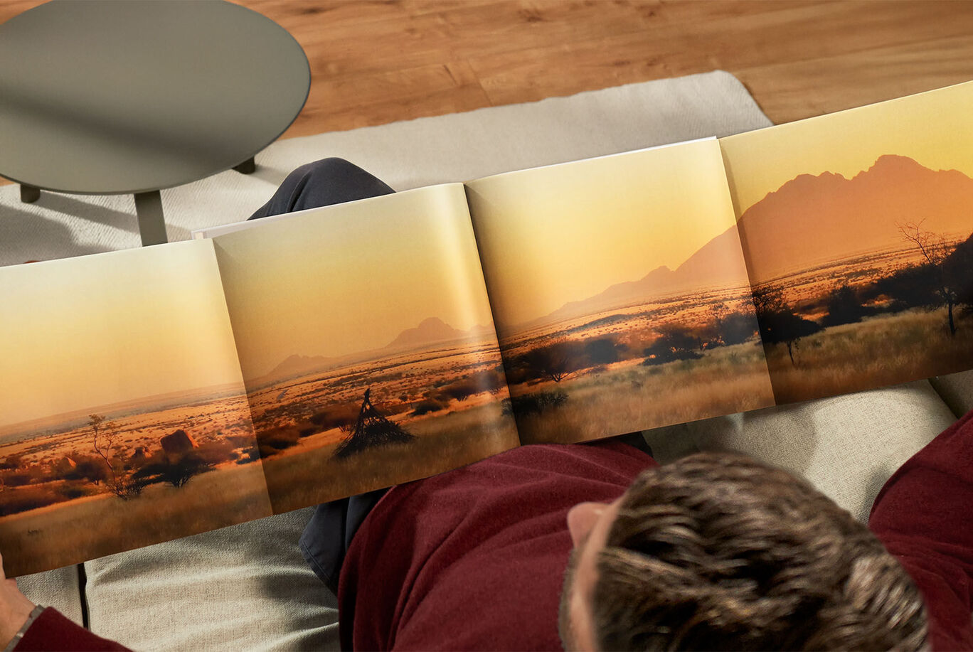 Personne assise sur un canapé regardant un livre photo avec souvenirs chaleureux.
