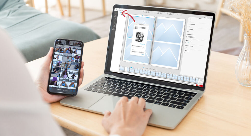 Person conçoit un livre photo CEWE sur un ordinateur portable avec un smartphone en main.