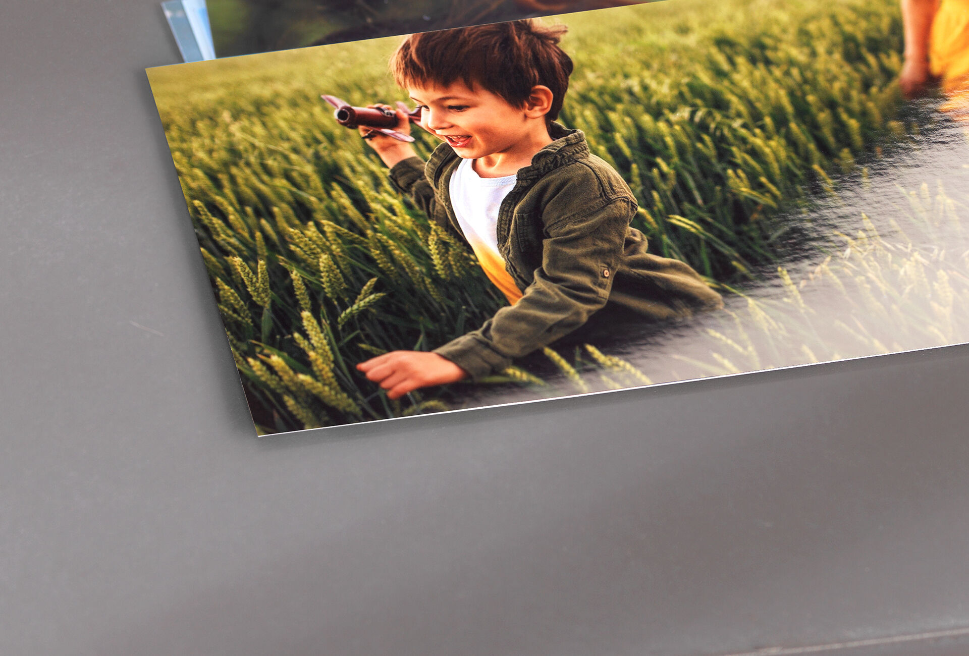 Un enfant court joyeusement à travers un champ et tient un jouet.